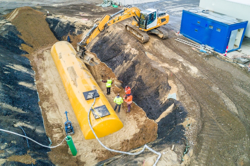 worker installing a huge fuel tank